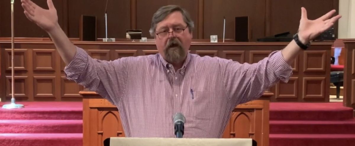 Rev. Steve Burton leading worship from the pulpit in the Cornerstone sanctuary